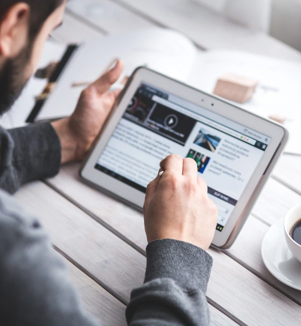 Persona leyendo noticias en una tablet, representando la difusión de estudios de CID Gallup en medios de comunicación nacionales e internacionales.